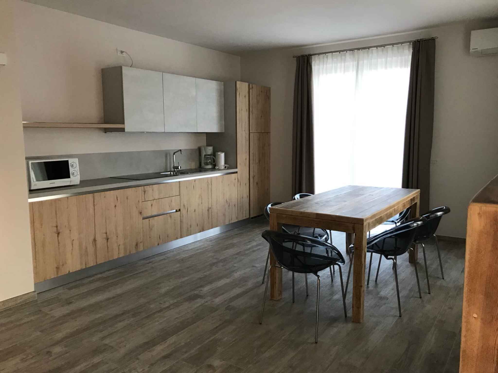 Une cuisine moderne avec des meubles en bois, un four à micro-ondes et une table à manger avec des chaises.