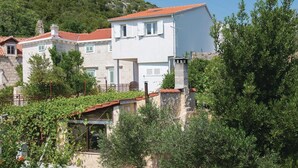 A white building with a red-tiled roof, stone walls, and green shutters. - 5 bedroom lovely home in Orebic (Orebic)