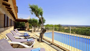 A poolside area with lounge chairs and a view of the landscape. - 750139 Sa Font near Petra (license ETV/941) - 750139 Sa Font (Petra)
