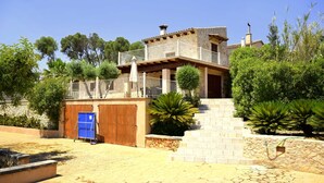 A two-story house with a balcony, a wooden door, and a stone staircase leading to the entrance. - 750139 Sa Font near Petra (license ETV/941) - 750139 Sa Font (Petra)