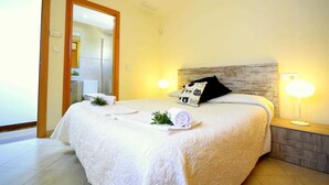 A hotel bedroom with a large bed, a nightstand, a lamp, and a mirror. - 44236 Modern beach house Es Baladre (Alcúdia)