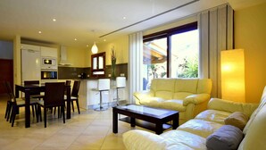 A modern living room with a sofa, coffee table, and dining area. - 44236 Modern beach house Es Baladre (Alcúdia)