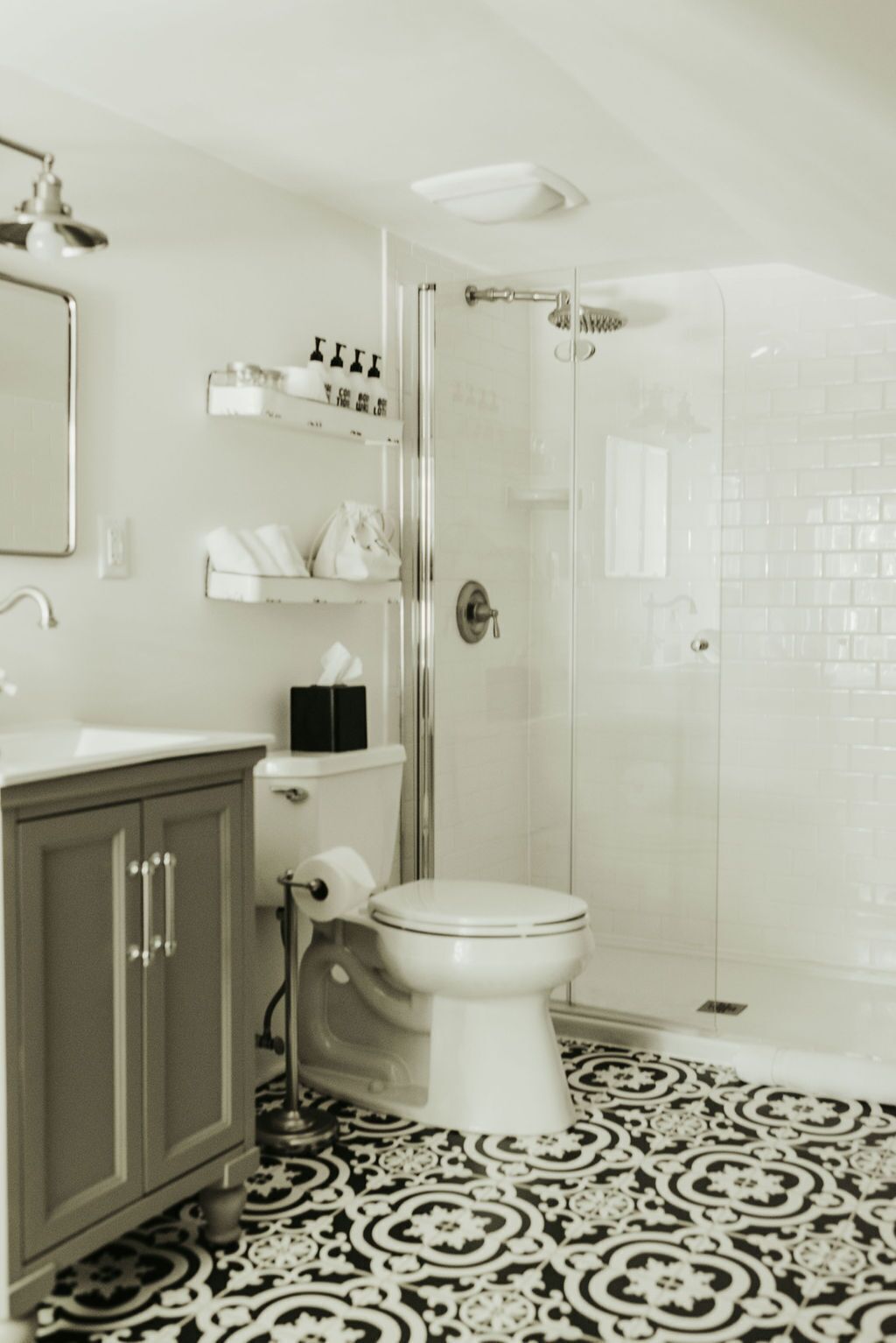 A bathroom with a toilet, a shower, and a sink.