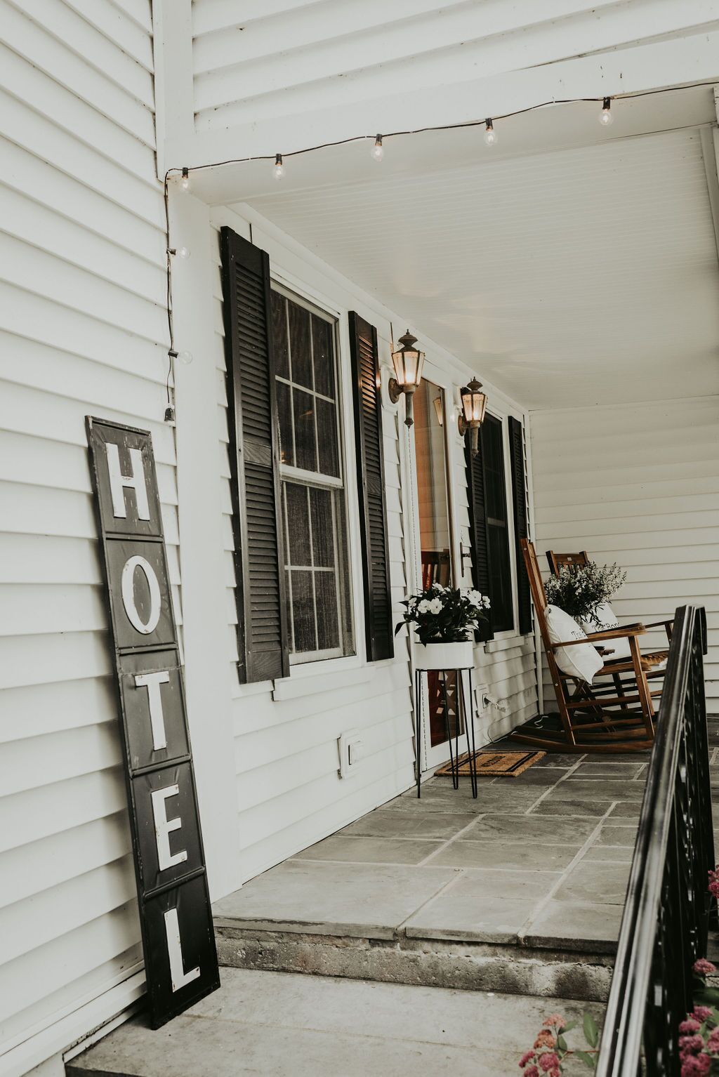 A hotel exterior with a porch, a 'HOTEL' sign, and a chair.