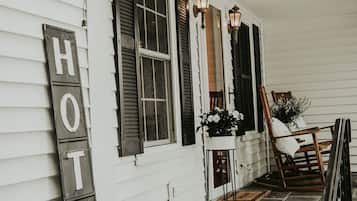 A hotel exterior with a porch, a 'HOTEL' sign, and a chair.