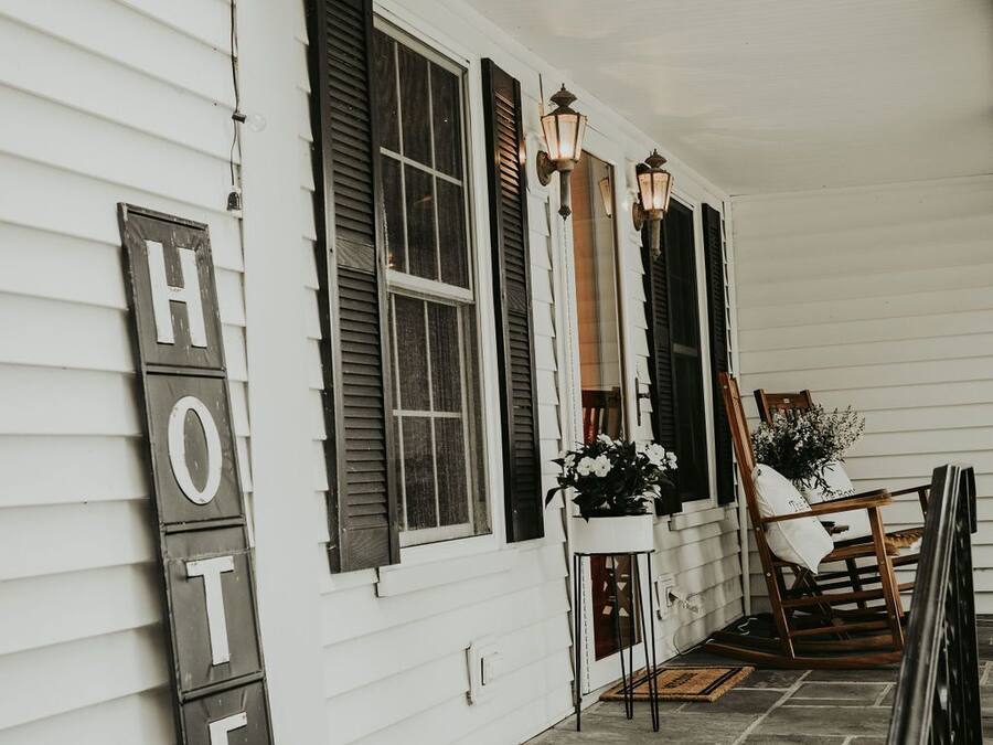 A hotel exterior with a porch, a 'HOTEL' sign, and a chair.