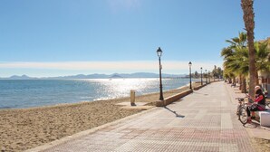 A seaside promenade with a tiled walkway, palm trees, and a clear view of the sea. - Stunning apartment in Los Alcazares with WiFi (Los Alcazares)