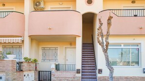 A multi-story building with a central staircase, balconies, and a tree in the foreground. - Stunning apartment in Los Alcazares with WiFi (Los Alcazares)