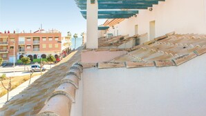 A rooftop with terracotta tiles, a white wall, and a blue wooden structure. - Stunning apartment in Los Alcazares with WiFi (Los Alcazares)