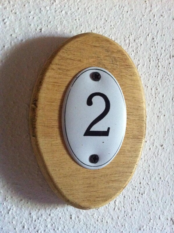 Una puerta de madera con una placa blanca que muestra el número 2.