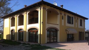 A yellow building with arched windows and a tiled roof.