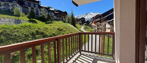 A balcony with a view of a mountain path and buildings.