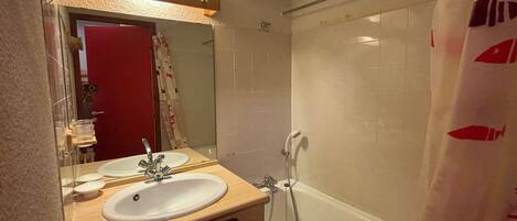 Un baño con dos lavamanos, ducha y espejo.