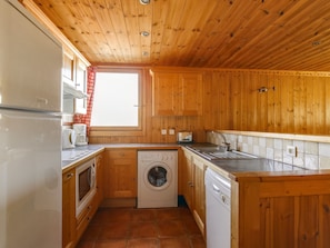 Enjoy a convenient kitchen with a washing machine and cabinetry for a comfortable stay.