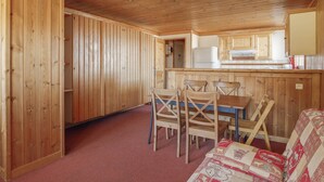 A wooden interior with a dining area, kitchen, and a cozy seating area. - Studio Cabin Arc 1600, 5 Persons, Ski-in/Ski-out, WiFi (Les Arcs 1600)