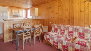 A wooden cabin interior with a dining area, a kitchen, and a cozy living space. - Studio Cabin Arc 1600, 5 Persons, Ski-in/Ski-out, WiFi (Les Arcs 1600)
