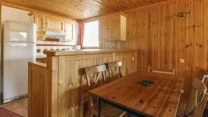 A wooden cabin interior with a kitchen, dining area, and a window. - Studio Cabin Arc 1600, 5 Persons, Ski-in/Ski-out, WiFi (Les Arcs 1600)