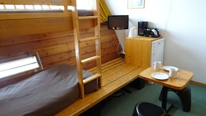 A bunk bed with a desk and chair, a small kitchenette, and a television. - Cozy studio Arc 1600, ski-in/ski-out, perfect for 2, WiFi included (Les Arcs 1600)