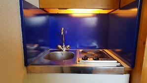 A compact kitchenette with a sink, stove, and wooden cabinet. - Cozy studio Arc 1600, ski-in/ski-out, perfect for 2, WiFi included (Les Arcs 1600)