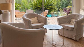 Une pièce dotée d’une grande porte-fenêtre coulissante donnant sur un espace extérieur aménagé avec des chaises et une table.