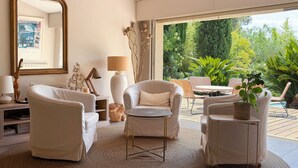A modern living room with a large mirror, a round table, and two armchairs. - Magnificent villa with heated infinity pool in Saint-Raphaël (Saint-Raphaël)