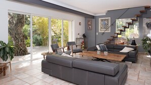 Un salon spacieux avec un canapé gris, une table basse en bois et une grande porte-fenêtre coulissante donnant sur un jardin.