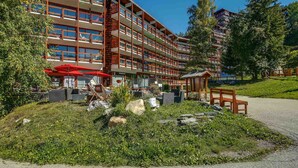 Un hôtel à plusieurs étages doté d’une terrasse et d’un jardin.