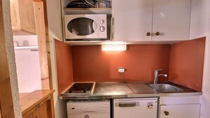 A compact kitchenette with a microwave, stove, sink, and a refrigerator. - Cozy studio for 4 in Vallandry, close to slopes (Peisey-Vallandry)