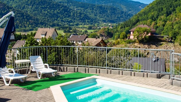 A pool area with lounge chairs and a view of a mountainous landscape. - Homerez - Apt in Oderen with mountain view (Oderen)