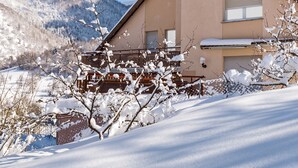 A building with a sloped roof, a balcony, and a view of snow-covered mountains. - Homerez - Apt in Oderen with mountain view (Oderen)