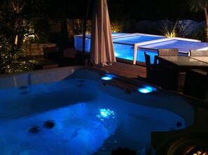 A hot tub with blue lighting, surrounded by outdoor furniture and a patio area. - Near Soulac/sea, private indoor heated swimming pool, jacuzzi, Sauna. (Grayan-Et-L'hôpital)