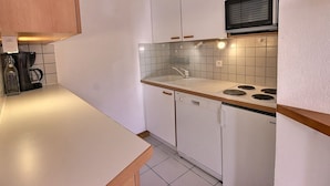 A compact kitchen with white cabinets, a microwave, a dishwasher, and a coffee maker. - 3-room apartment in Vallandry, southwest terrace, pets allowed (Peisey-Vallandry)