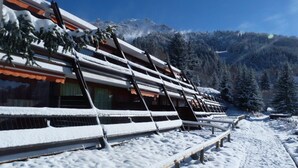 Un edificio cubierto de nieve con techo inclinado y barandillas de madera.