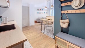 A modern kitchen with wooden countertops, a dining area with wicker chairs, and a wall-mounted hat rack. - N&J - PLACE DU PIN - Port - Close Old Town (Niza)
