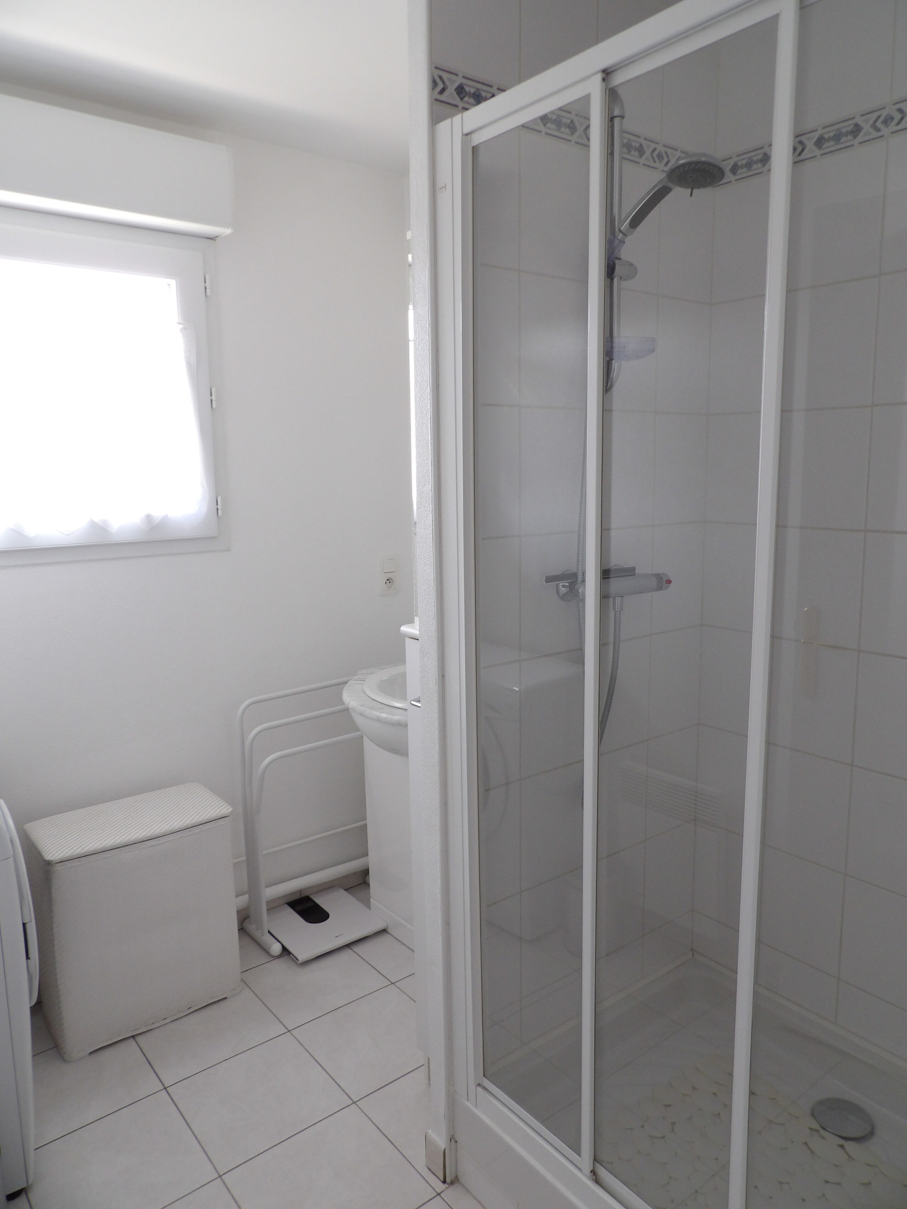 Een badkamer met een douchecabine, een toilet en een wastafel.