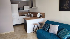 Una cucina moderna con mobili bianchi, un piano di lavoro in legno e una penisola centrale con sgabelli.