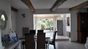 Un comedor con una mesa y sillas, un refrigerador y un mueble de madera.