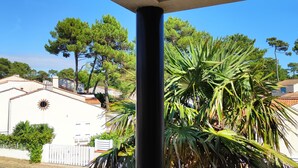 Un quartier résidentiel avec des maisons blanches, un palmier et un ciel bleu azur.