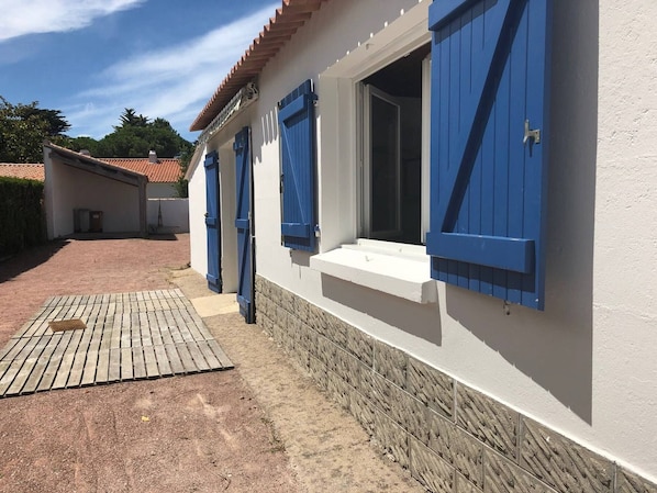 Stylish building with a red-tiled roof and blue-shuttered windows.