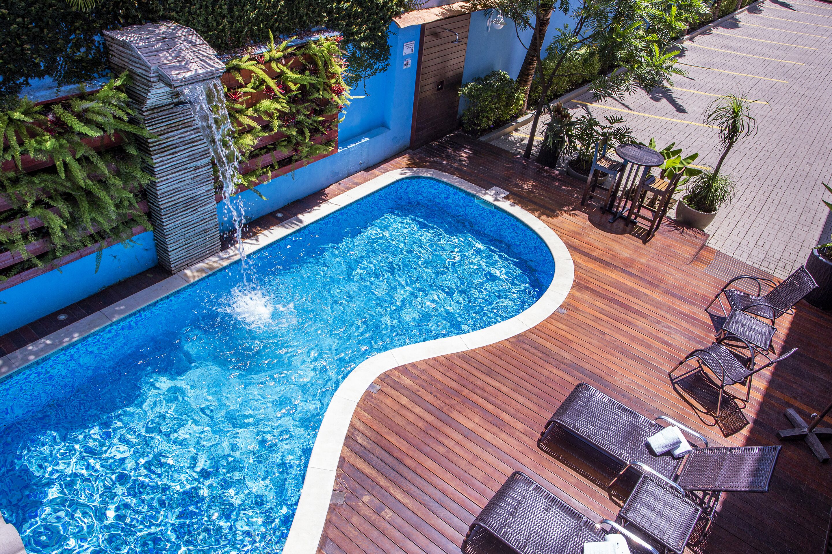 Una piscina al aire libre, sillones reclinables de piscina