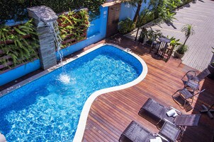 Una piscina al aire libre, tumbonas