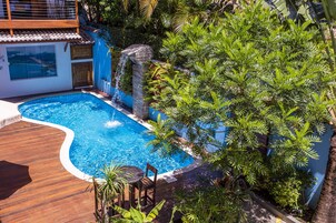 Una piscina al aire libre, sillones reclinables de piscina