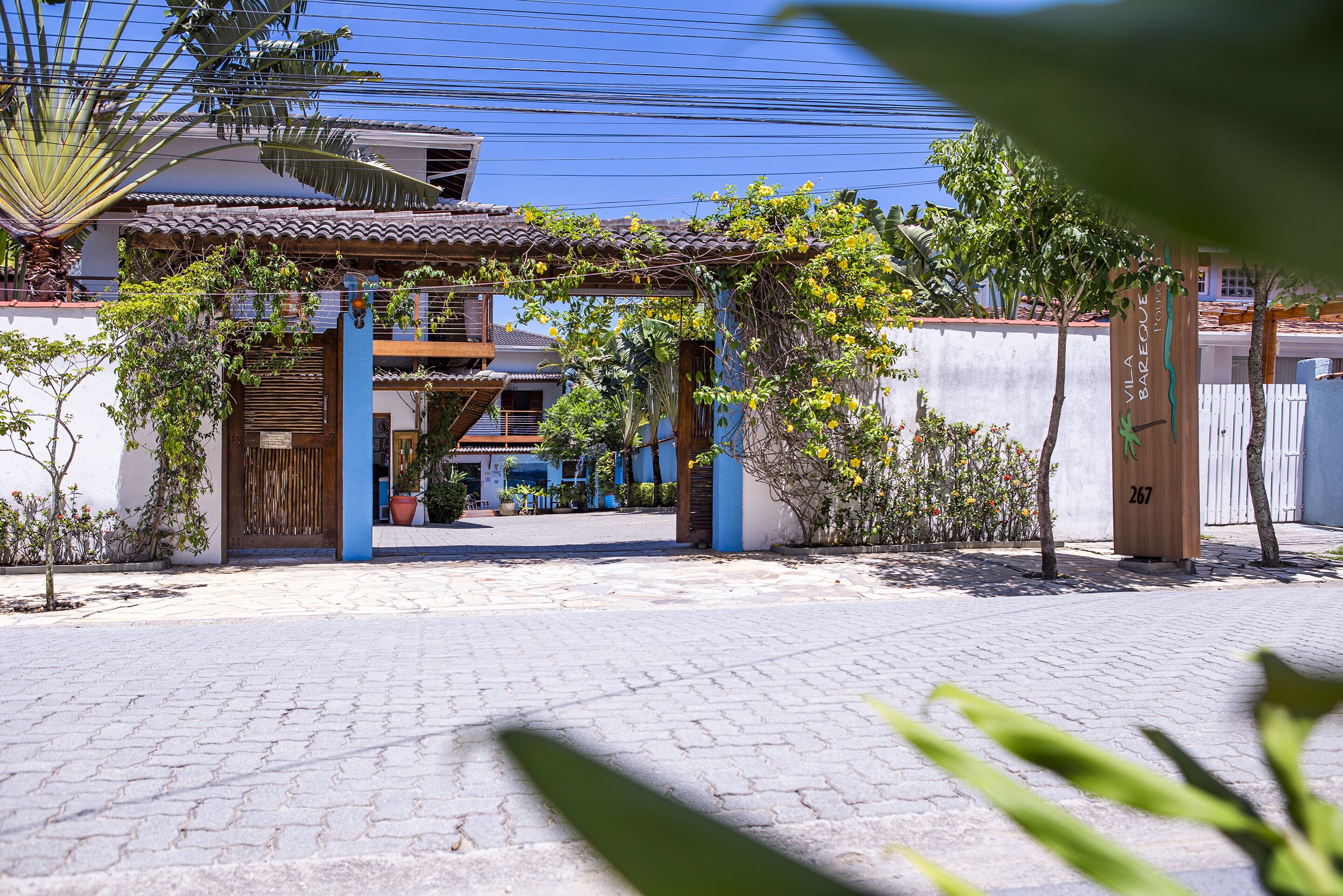 Una casa tradicional con tejado de tejas, un portón de madera y un patio empedrado.