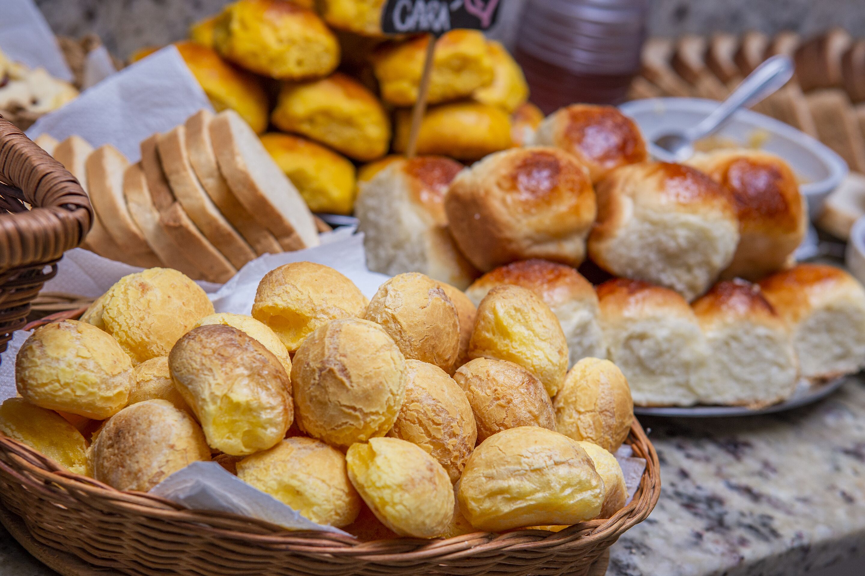 Un panier rempli de petits pains et de viennoiseries fraîchement sortis du four.