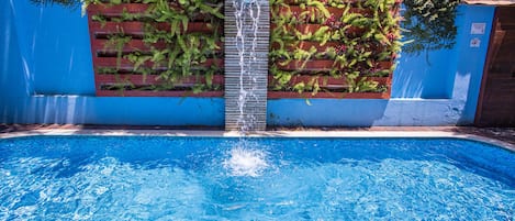 Una piscina al aire libre, sillones reclinables de piscina