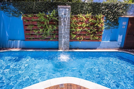 Una piscina al aire libre, sillones reclinables de piscina