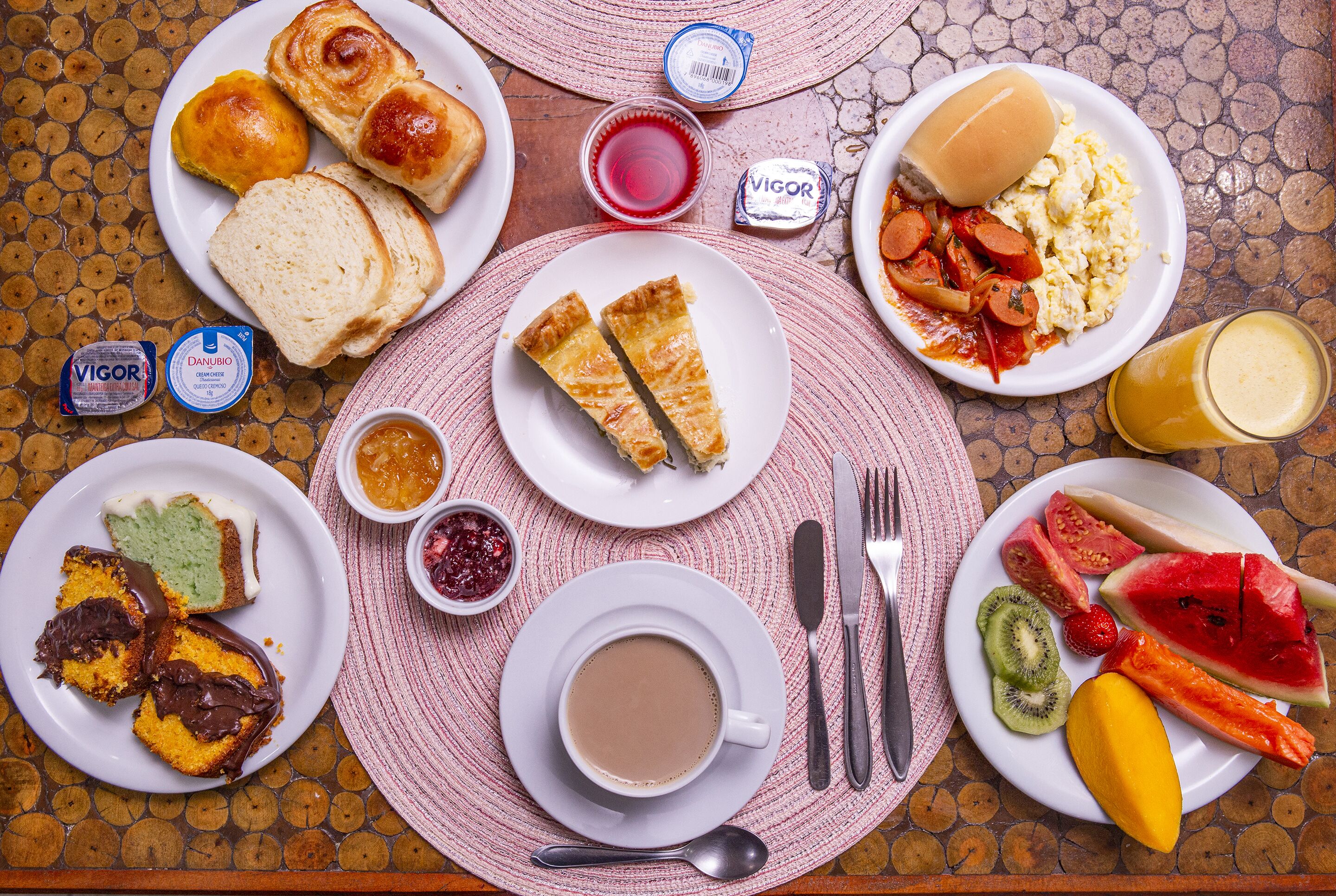 A table with various breakfast items including toast, eggs, sausages, and fruit.