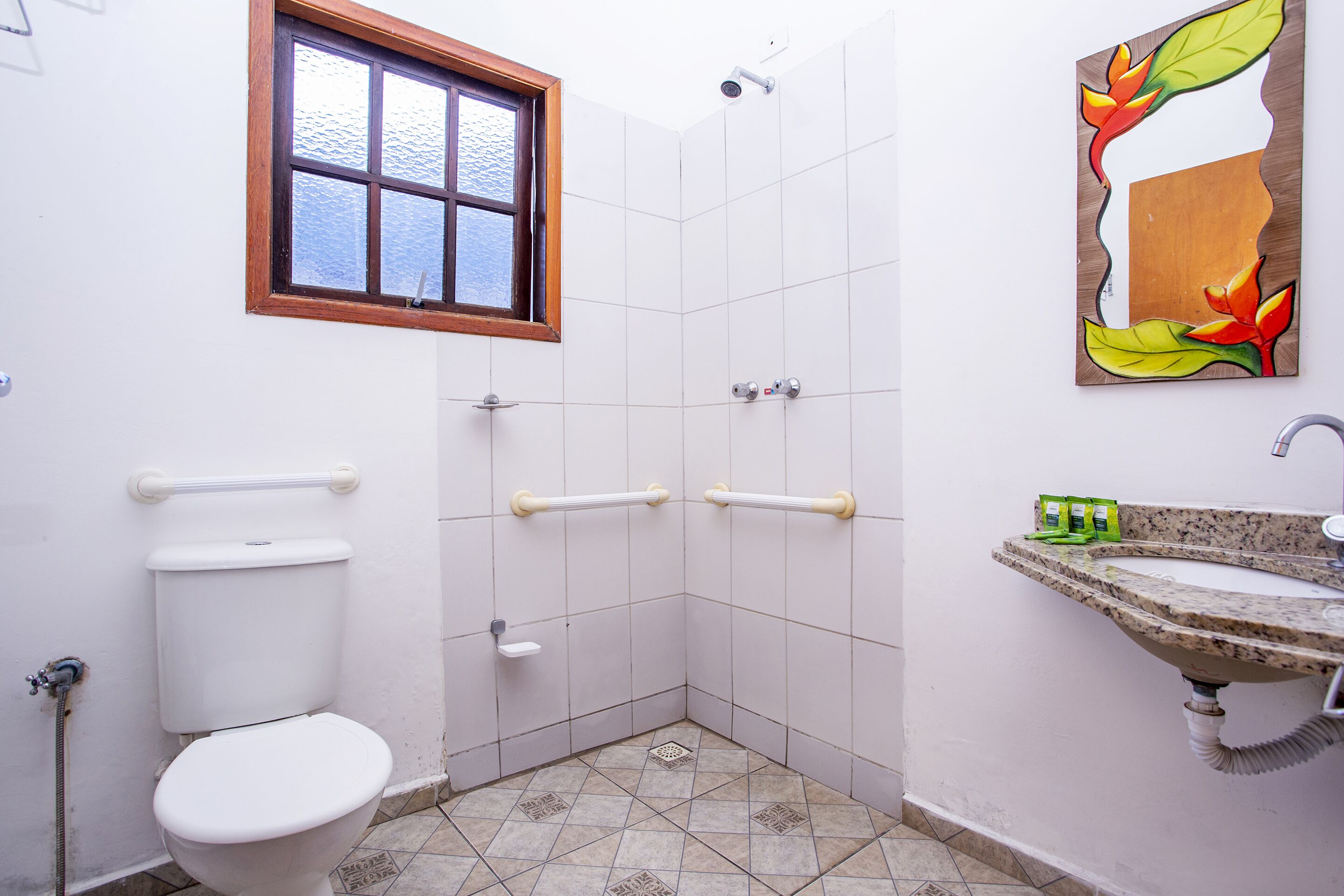 A bathroom with a toilet, shower, and sink.