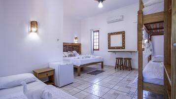 Una habitación limpia y bien iluminada con una cama, un escritorio, un espejo y un ventilador de techo.