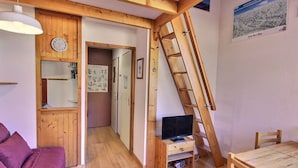 A cozy room with a wooden ceiling, a TV on a wooden stand, a wooden table, and a purple sofa. - Studio for 4 in Vallandry, near slopes (Peisey-Vallandry)